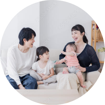 明るいリビングでソファに座り、笑顔で会話を楽しむ4人家族