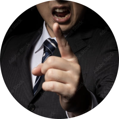 スーツ姿の男性が激しく指を突きつけながら怒鳴っている様子